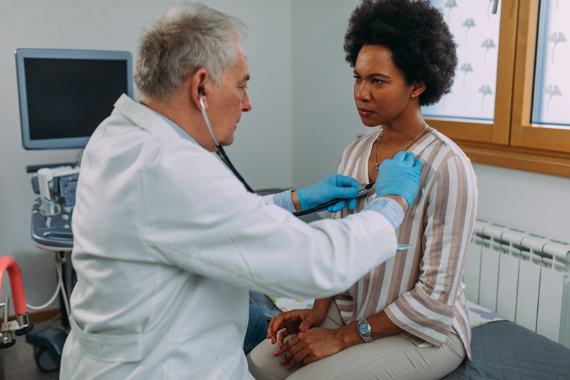 Male doctor examining female patient. They are at hospital office